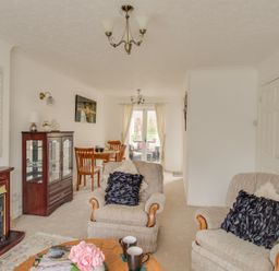 A living room with two armchairs a wooden coffee table a fireplace and a dining table at Casa Carmen Weymouth