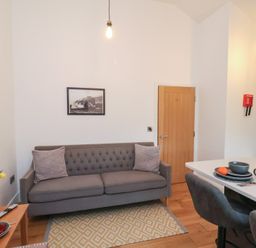 A living room with a sofa and dining table at Evening Star @ Engine Shed in Whitby