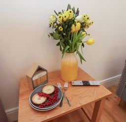A table with flowers, food, and a remote control at Evening Star @ Engine Shed Whitby