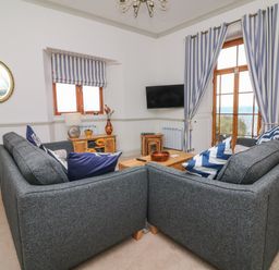 A living room with two gray sofas and blue striped curtains at Bayview Terrace in Lynton