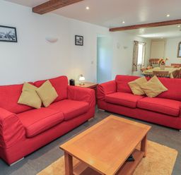 A living room with red sofas and a coffee table at Dale Barton in Wells
