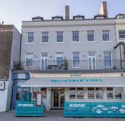A building with a rockfish restaurant on the ground floor and residential windows above at 6 The Beaches in Weymouth