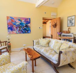 A living room with sofa and artwork at Pheasant Cottage in Priston Village, BATH