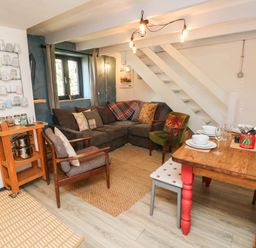 A living room with a sofa and dining table at Farmhand Cottage near Narberth