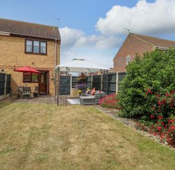 A garden with a table and chairs under a canopy at Breydon Cottage in Bradwell near Gorleston-On-Sea