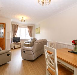 A living room with a table and chairs at Breydon Cottage in Bradwell near Gorleston-On-Sea
