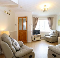 A living room with two recliner chairs and a television at Breydon Cottage in Bradwell near Gorleston-On-Sea