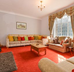 A living room with colorful cushions on sofas and a wooden coffee table at Southrepps Lodge in Southrepps