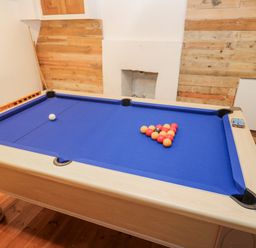 A pool table with arranged balls in a game room at Labour in Vain St Ives