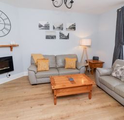 A living room with sofas and a coffee table at Hasting Dairy in North Sunderland near Seahouses