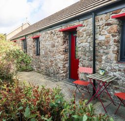 An outdoor area with stone wall, furniture and plants at Grain Store near Narberth