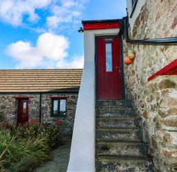 A staircase leading to a red door at Hayloft near Narberth