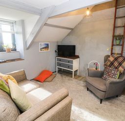 A living room with a sofa and armchair at Hayloft near Narberth