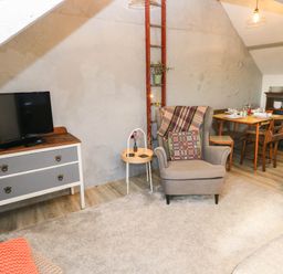 A living room with a television and seating at Hayloft near Narberth