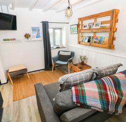 A living room with a sofa and armchair at Milking Shed near Narberth