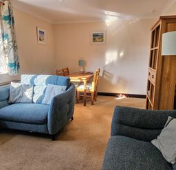 A living room with a sofa and table at Chiffchaff in Padstow