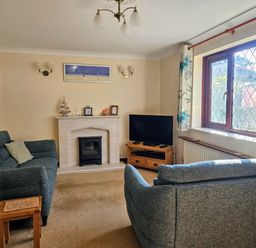 A living room with a fireplace and television at Chiffchaff in Padstow