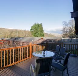 A deck with a table and chairs overlooking hills at Heights View