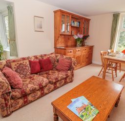 A living room with a patterned sofa wooden coffee table and dining table with chairs at West Burnbank in Tarset near Bellingham