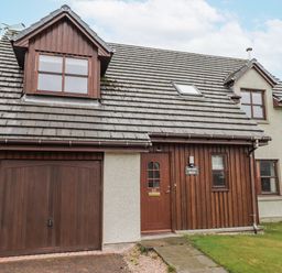 A house with a garage and front door at Burnside House in Aviemore