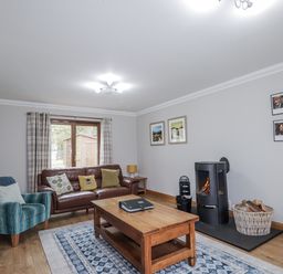 A living room with a sofa and fireplace at Burnside House in Aviemore