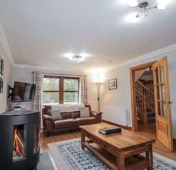 A living room with a sofa and coffee table at Burnside House, Aviemore