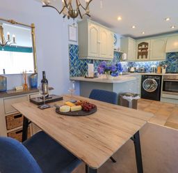 A kitchen with a dining area featuring a table and chairs at Waterhead Cottage, Ecclerigg, near Troutbeck Bridge