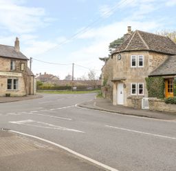 A street intersection with stone buildings including The Fox and Hounds pub at Pike Cottage in Acton Turville near Chipping Sodbury