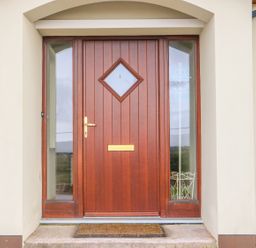 A wooden front door with glass panels on each side and a doormat at Rossanean Farranfore near Killarney County Kerry