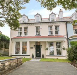 A large two story house with dormer windows and a driveway at Lyngaran House in Holyhead