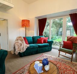 A living room with a green sofa and coffee table at Ael Y Bryn in Menai Bridge
