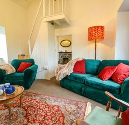 A living room with a green sofa and coffee table at Ael Y Bryn in Menai Bridge