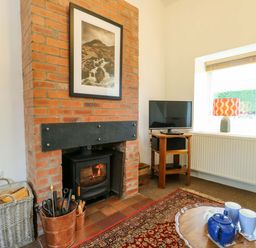 A living room with a fireplace and television at Ael Y Bryn in Menai Bridge