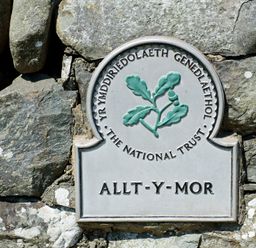 A stone wall with a National Trust plaque that reads Allt-y-Mor