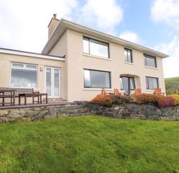A house with a patio and furniture at Bryn Deryn in Criccieth
