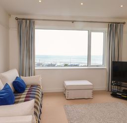 A living room with a sofa and TV at Bryn Deryn in Criccieth
