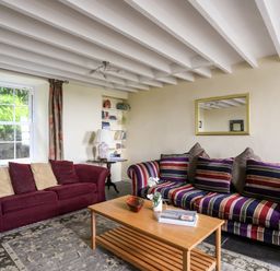 A sitting room with two sofas a wooden coffee table and a bookshelf at Bron Castell in Harlech