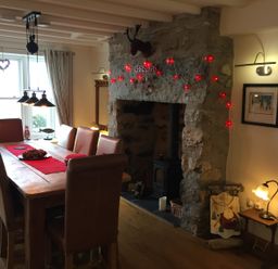 A dining room with a table and chairs at Cae'r Dyni (Caer Dyni) Criccieth