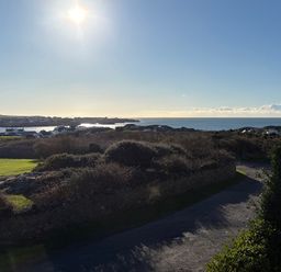 A scenic view of the ocean and houses at Curragho in Trearddur Bay