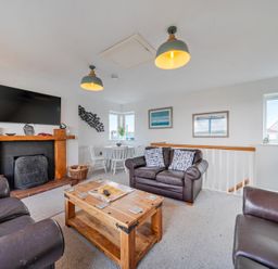 A living room with a television and seating area at Curragho in Trearddur Bay