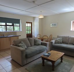 A living room with a sofa and table at Bryn Eira Tack Room Llanfair PG