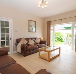 A living room with a sofa and coffee table at Menai Cottage in Brynsiencyn