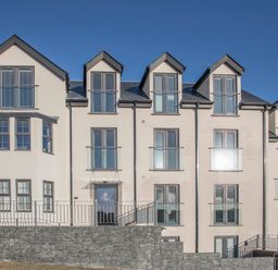 A multi-story residential building with multiple windows and balconies at The Pot Loft in Benllech