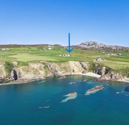 A coastline with cliffs and a house at Ty Nant in South Stack
