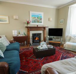 A living room with a fireplace and television at West View in Rhosneigr