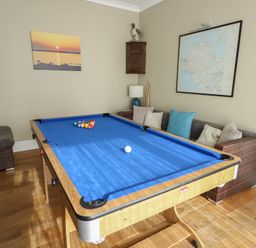 A game room with a pool table and wall art at West View in Rhosneigr