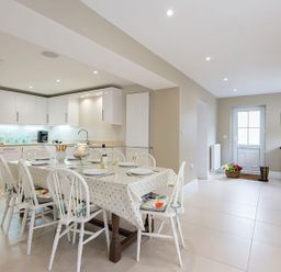 A kitchen with a dining table and chairs at West View in Rhosneigr