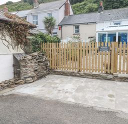 An outdoor area with a sign for Pebble Cottage in Portreath
