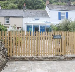 A garden area with a fenced entrance at Pebble Cottage in Portreath