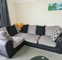 A living room with a sofa and cushions at Sea Breeze in Rhos-on-Sea